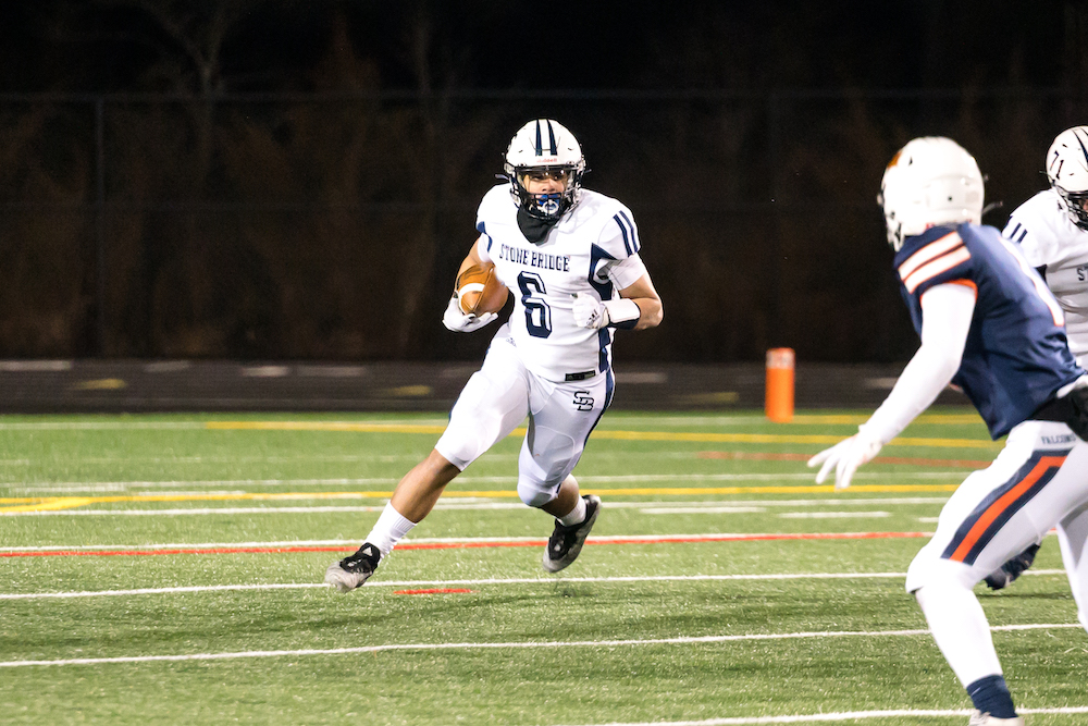 Stone Bridge junior running back Eli Mason carries the ball in a win over Briar Woods on March 5 in Ashburn